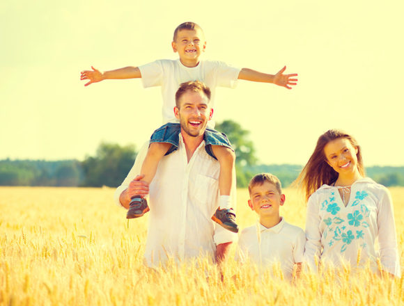 Happy young family on wheat summer field Was den Menschen in die Metropole zieht: Vom Paradies in die Stadt