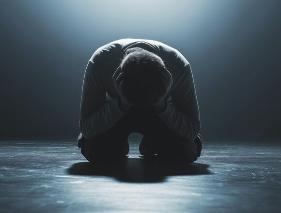 repent Ein eindringliches Porträt eines jungen Mannes, der auf dem Boden kniet, tief in Reue versunken. Seine Haltung strahlt Demut und innere Zerknirschung aus, während sein Blick nach unten gerichtet ist, von einem leisen Licht der Hoffnung umspielt.