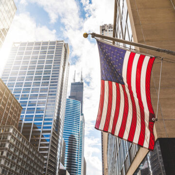 USA-Flagge in Chicago mit Wolkenkratzern im Hintergrund