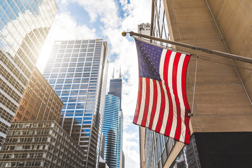 USA-Flagge in Chicago mit Wolkenkratzern im Hintergrund