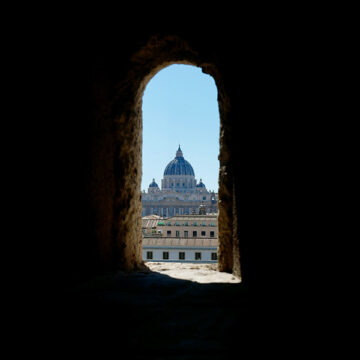 Ansicht der Petersbasilika in Rom durch eine kleine Öffnung in einer Mauer.