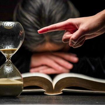 Finger of Person Pointing to Time while Woman Sleeps Over Bible