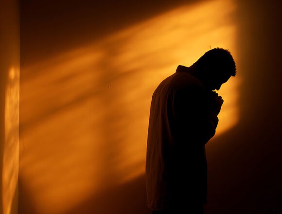 seelische-heilung Auf der Suche nach Hoffnung: Silhouette eines Mannes, der in schwierigen Zeiten um Führung und Kraft betet. Spiritualität und Glaube – Konzept für redaktionelle Zwecke, Blog-Inhalte und Sensibilisierung für psychische Gesundheit