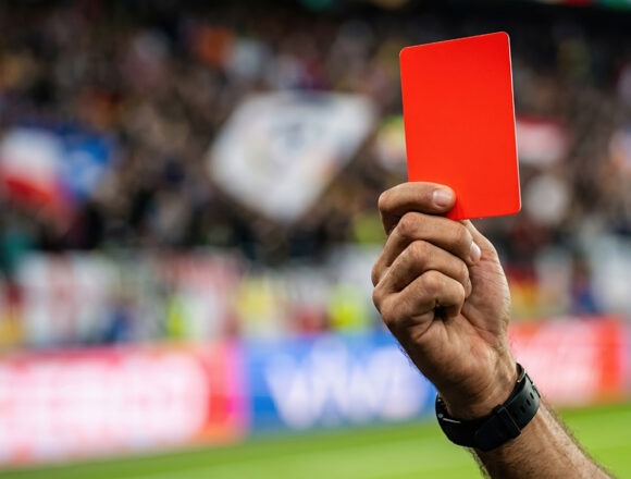 rote-karte Ein Schiedsrichter zeigt in einem Fußballspiel eine rote Karte.